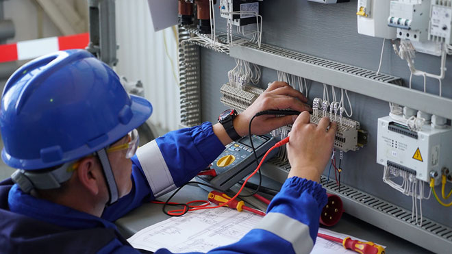 Un inginer electrician verifică și instalează circuite electrice. 